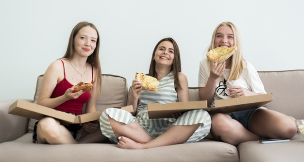 手づかみでピザを頬張る女子3人組
